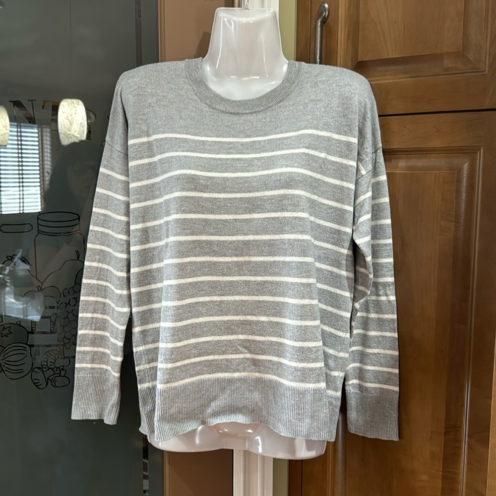 Grey sweater with white stripes. It’s still like new. Size Medium